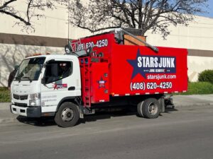 A Stars Junk Removal truck loaded with various debris and junk, parked on a street in San Jose, CA