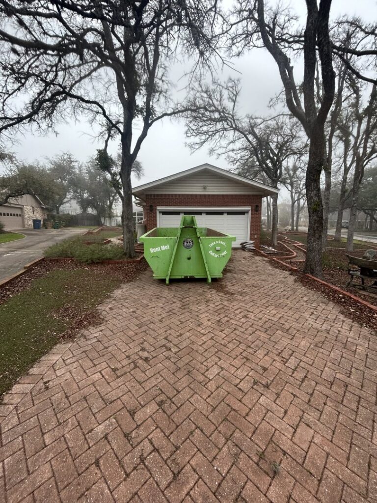 A 1-800-JUNKPRO junk removal truck loaded with black trash bags and various items in Austin, TX.