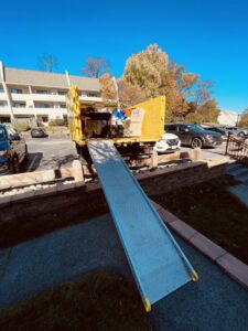 A Junk to Go truck with an extended ramp ready for loading items during a junk removal service in Philadelphia, PA.
