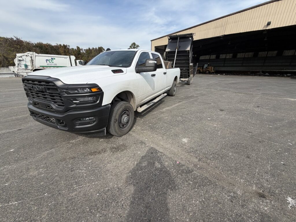 A white pickup truck with a dump trailer used for junk removal by Bring That Junk Removal and Demolition in Jacksonville, FL.