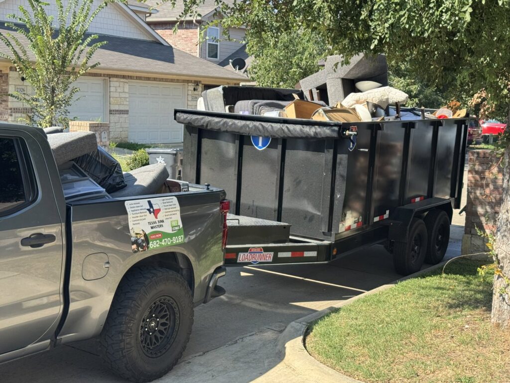 A Texas Junk Masters truck and trailer loaded with furniture and household junk for removal in Fort Worth, TX.