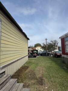 A Clear Your Junk - Pearland truck and trailer in a mobile home park, ready for or completing a junk removal job in Houston, TX.