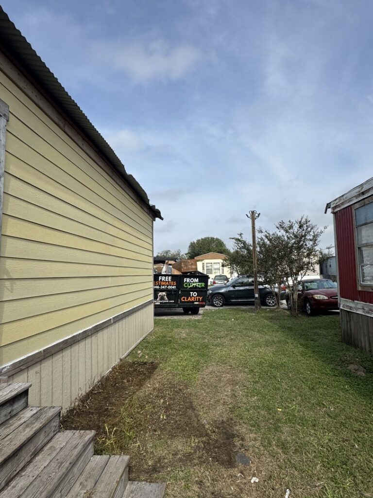 A Clear Your Junk - Pearland truck and trailer in a mobile home park, ready for or completing a junk removal job in Houston, TX.