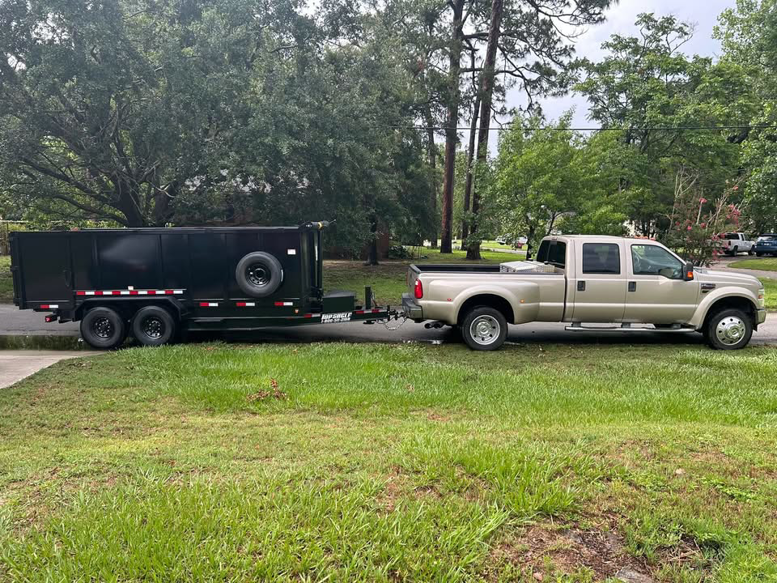 A heavy-duty pickup truck towing a large empty dump trailer for junk removal services by River City Junk and Debris Removal in Jacksonville, FL.