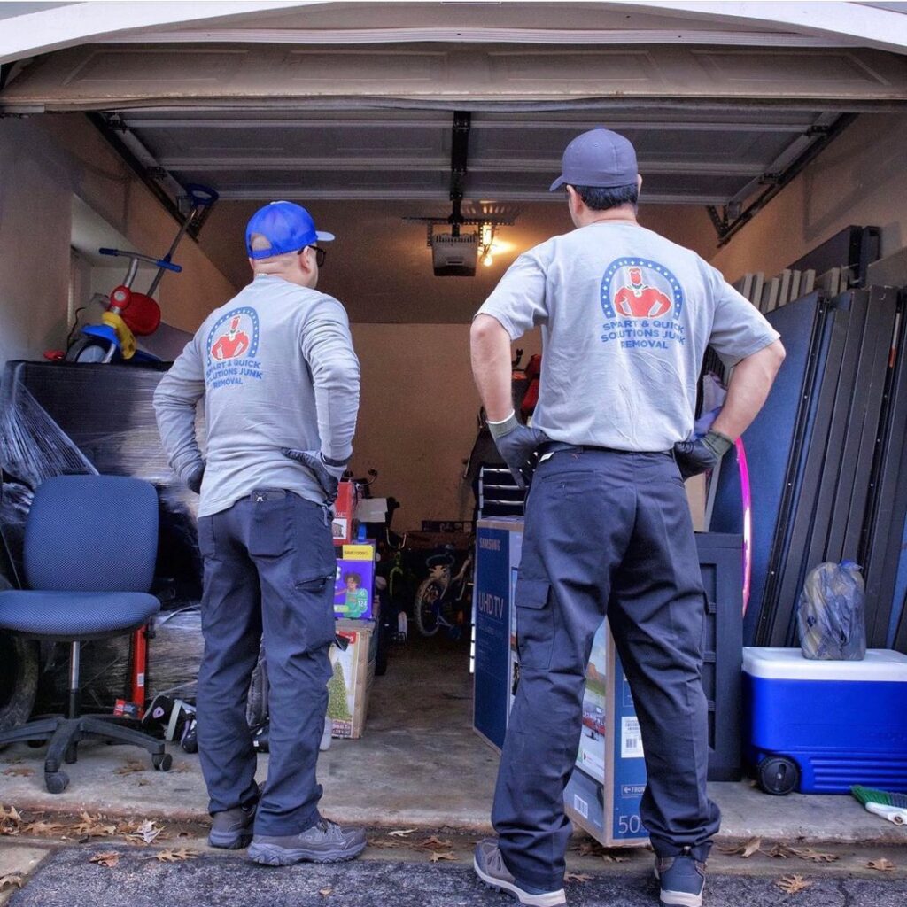 A SQS Junk Removal truck with an empty roll-off dumpster parked on a residential street in Charlotte, NC.