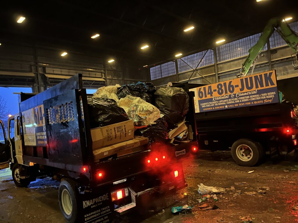 Two junk removal trucks dumping waste at a facility after a job by Lug Stars Junk Removal in Columbus, OH.