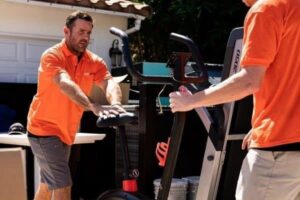 JunkMD team members removing an exercise bike and treadmill from a property in San Diego, CA.