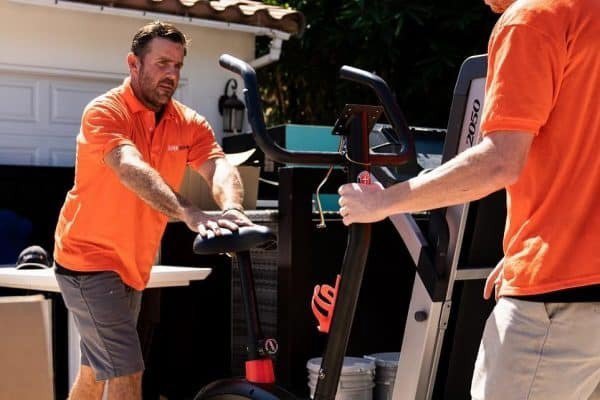 JunkMD team members removing an exercise bike and treadmill from a property in San Diego, CA.
