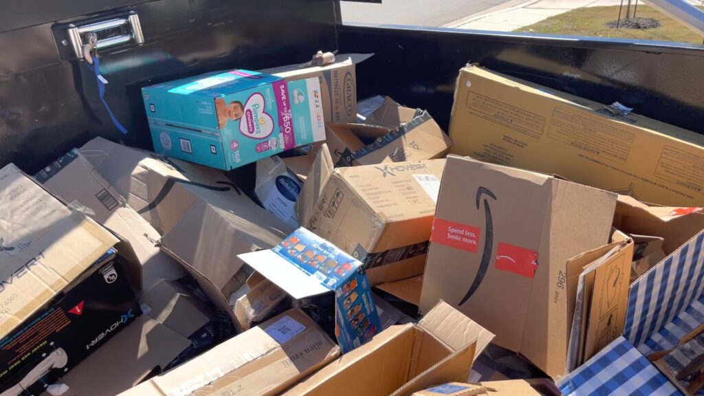 A JunkStart truck bed completely filled with various cardboard boxes ready for disposal in San Antonio, TX.