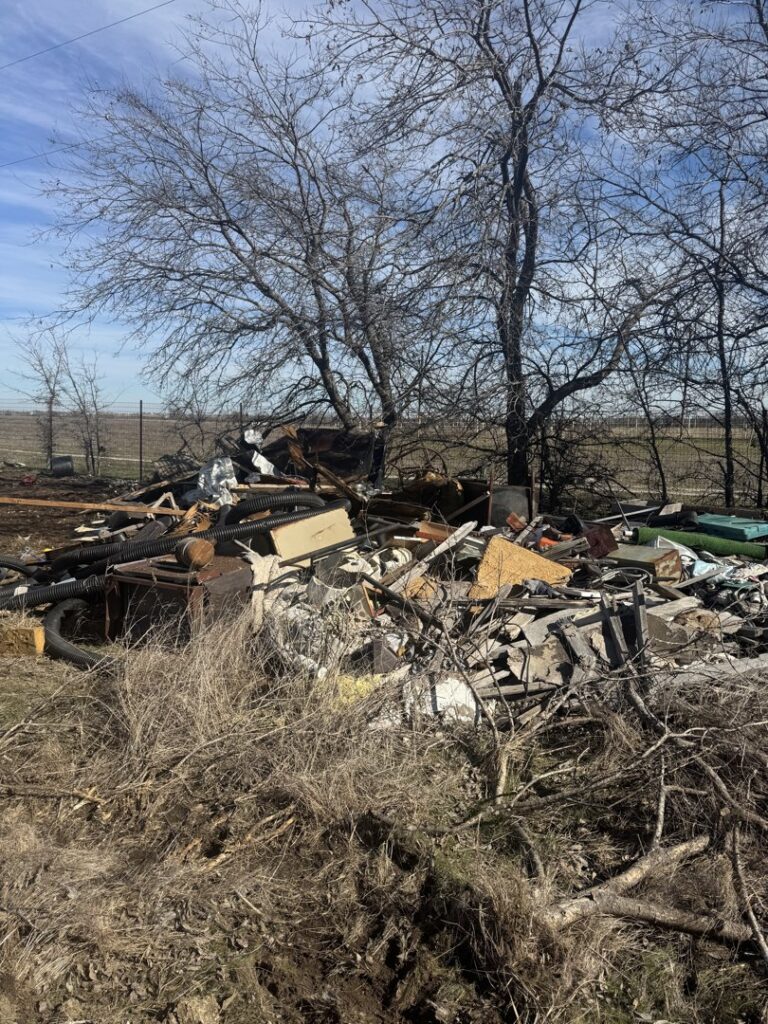 A massive pile of mixed outdoor debris and trash, indicating a large-scale cleanup by Eagle Junk Removal in Fort Worth, TX.