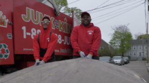 A large pile of household junk, boxes, and bags on a driveway, ready for removal by Junk King San Antonio Northwest in San Antonio, TX.