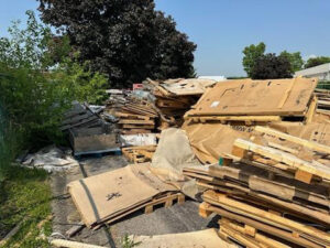 A large pile of cardboard boxes and wooden pallets outdoors, awaiting junk removal by ABC Junk Removal & Hauling in Westfield, IN.