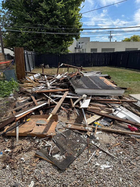 A large pile of demolition debris and general junk awaiting removal in a backyard by Load & Go Hauling Junk Removal in Grove City, OH.