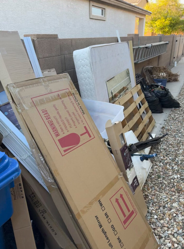 A large pile of household junk including cardboard, a mattress, and trash bags, ready for removal by Minutemen Junk Removal in Phoenix, AZ.