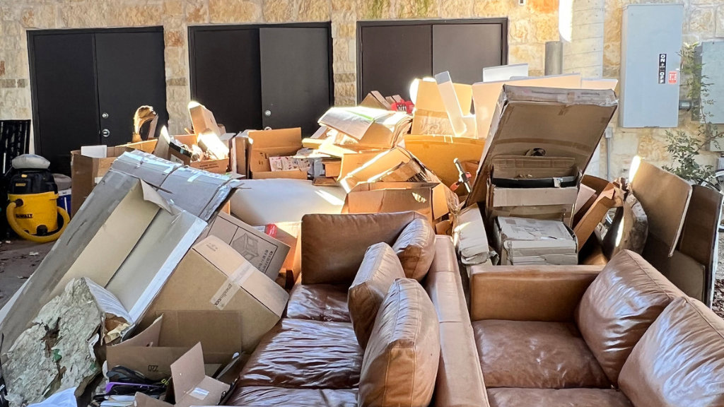 A large pile of cardboard boxes, furniture, and general debris awaiting removal by IHaul Austin in Austin, TX.
