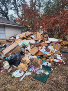 A large pile of household junk and debris in a residential yard, ready for removal by Just Junk It Disposal in Jonesborough, TN.