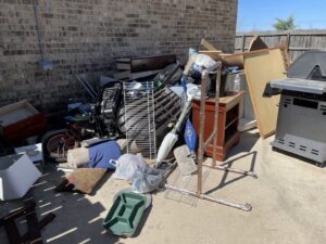 A large pile of patio junk, including a grill, furniture, and various debris, ready for Firefighter Junk Removal in Austin, TX.