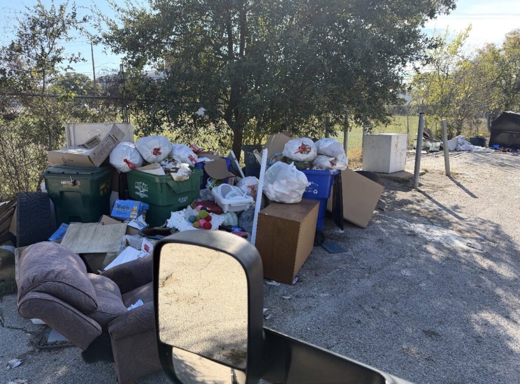 A large pile of trash bags, boxes, and an old armchair awaiting junk removal by Junk Out Boyz LLC in Austin, TX.