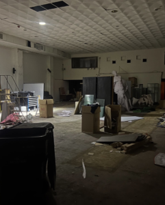 A large room with scattered boxes and debris, indicating a cleanout service by JUNK BOX LLC in Philadelphia, PA.