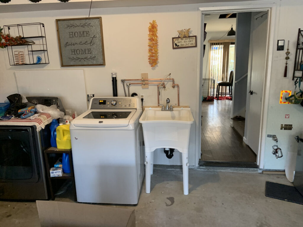 A laundry room with a utility sink and visible plumbing connections installed by JG Water Heaters, Filtration and Plumbing in San Diego, CA