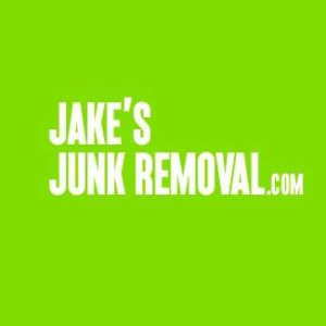 A man carrying a large log to be loaded into a Jake's Junk Removal truck in San Diego, CA.