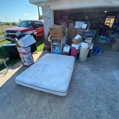 A mattress and several boxes placed outside a garage for junk removal by Texas Strong Hauling and Junk Removal in San Antonio, TX.