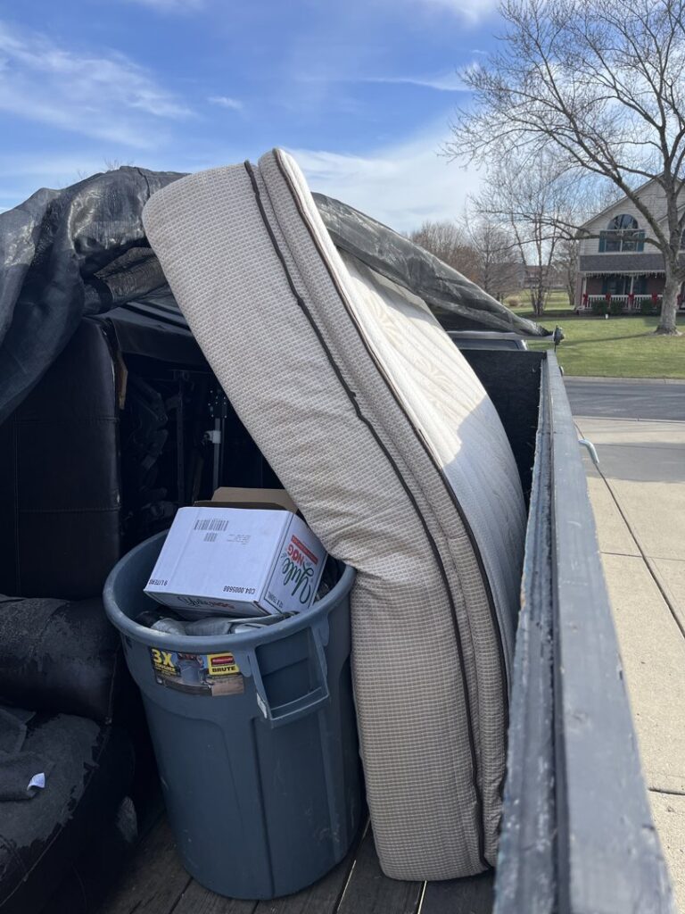 A mattress and various household junk items loaded into a trailer by Junk Removal of Hancock County in Indianapolis, IN.