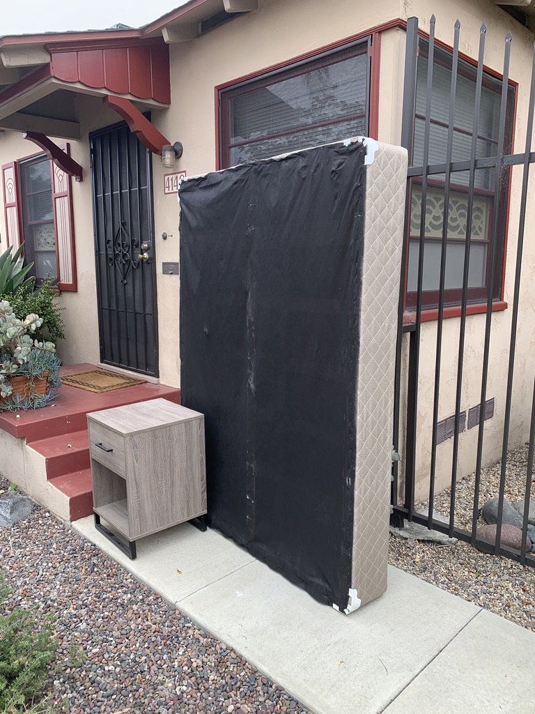 A mattress and a nightstand placed outside a house for pickup by Fred's Junk Removal in Chula Vista, CA.
