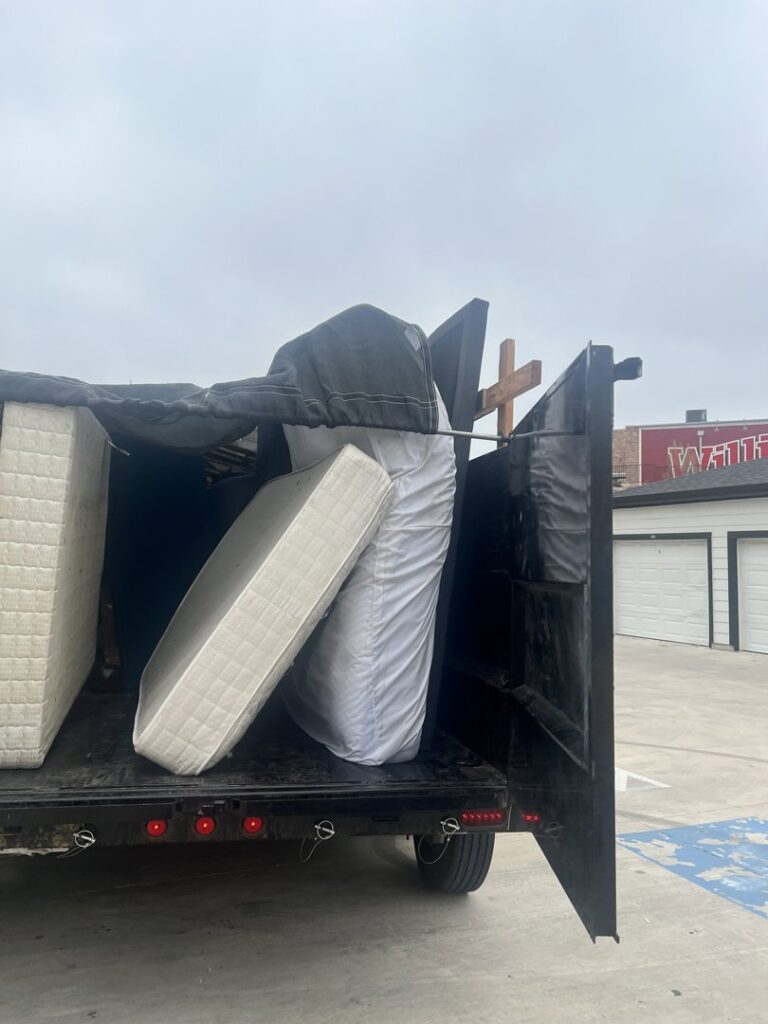 A dump trailer loaded with mattresses and other large items for removal by Silverhull Junk Removal in San Antonio, TX.