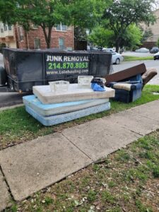 Mattresses and an armchair placed curbside for junk removal by Lolo Hauling Junk Removal in Dallas, TX.