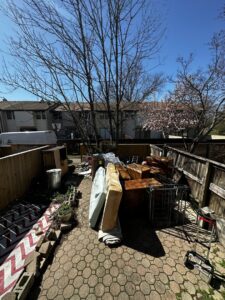 A large pile of mattresses and furniture in a backyard for removal by S&M Junk Removal in Philadelphia, PA.