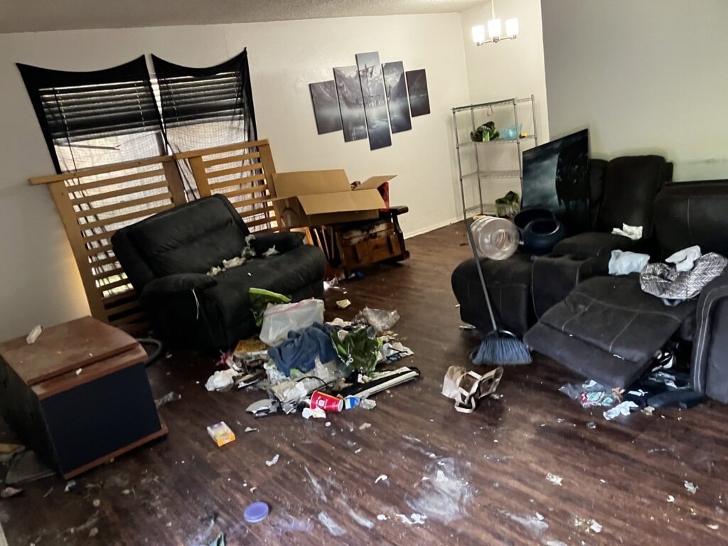 A messy living room filled with discarded furniture, boxes, and debris, ready for junk removal by Junkie 4 Jesus Junk Removal in Austin, TX