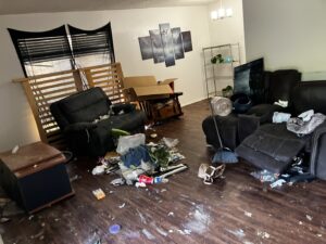 A messy living room filled with discarded furniture, boxes, and debris, ready for junk removal by Junkie 4 Jesus Junk Removal in Austin, TX