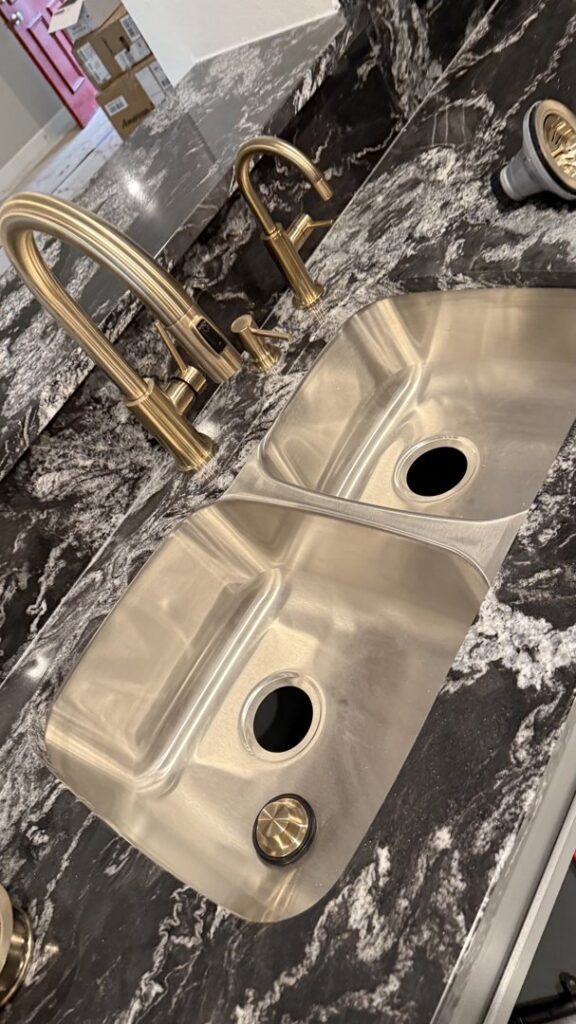 A new kitchen sink and gold-toned faucet installation by Economy Plumbing Services in Austin, TX