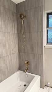 A newly installed shower head and faucet in a tiled bathroom by Economy Plumbing Services in Austin, TX