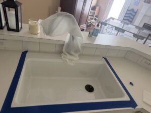 A newly installed kitchen sink with blue painter's tape, completed by Dallas Plumbing Company in Dallas, TX.