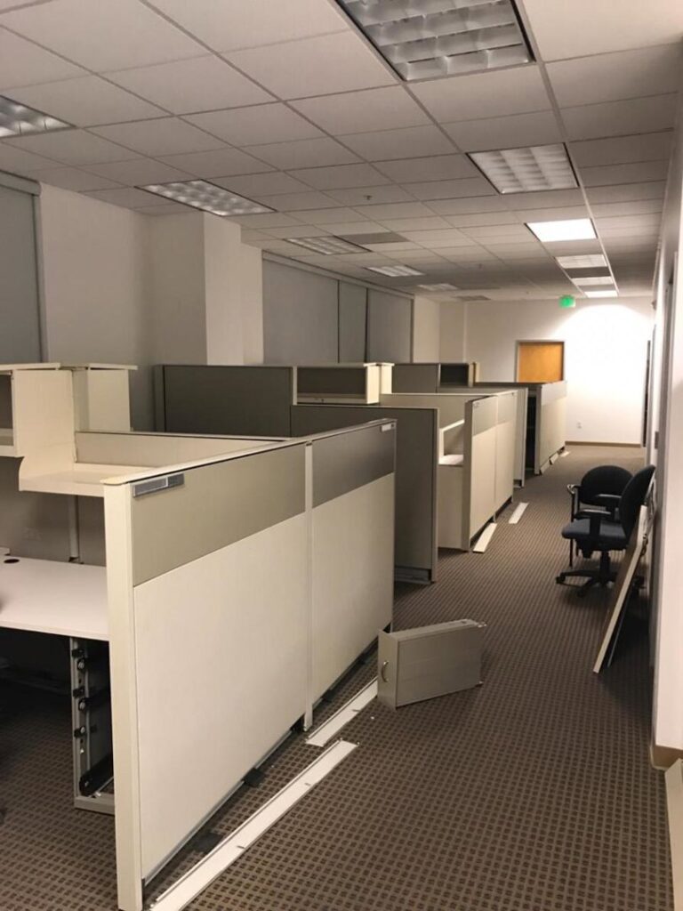 An office space with disassembled cubicle walls and chairs, indicating a commercial junk removal job by Zen Junk in San Jose, CA.