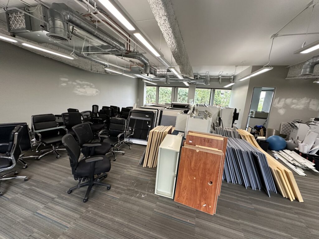 An office space filled with discarded furniture and debris, ready for commercial junk removal by Haul Away Any Day, San Diego, CA.