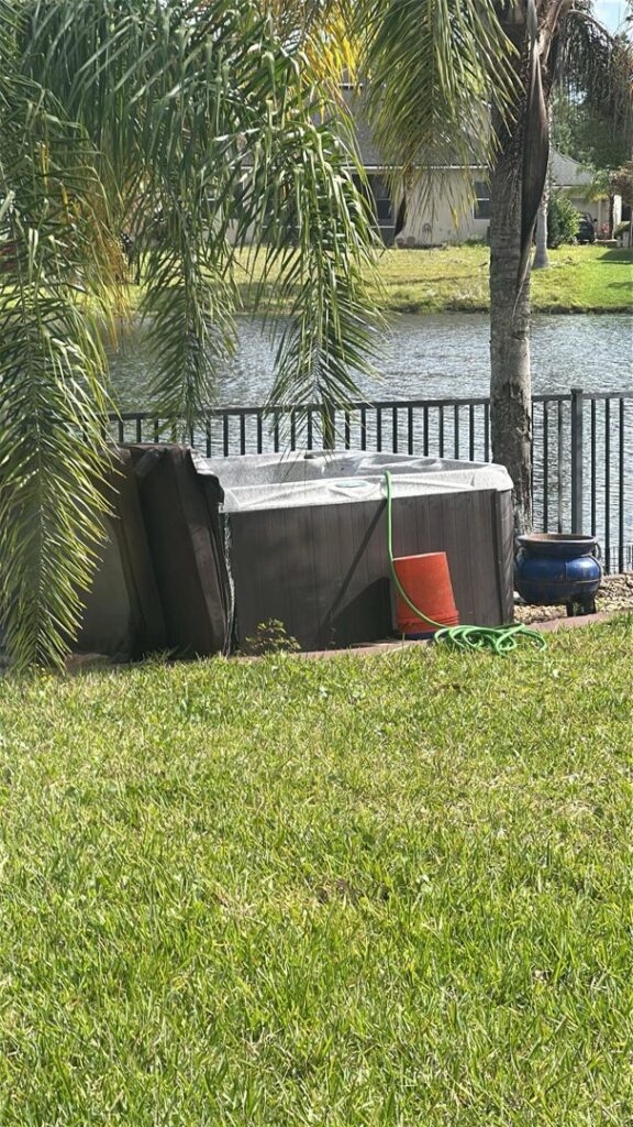 An old, broken hot tub in a backyard, ready for removal by Clean Tidy Places, a junk removal service in Jacksonville, FL.