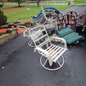 Old patio furniture and a grill placed on a driveway, ready for general junk removal by Purefoy's Professionals in Columbus, OH.