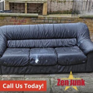 An old, worn black leather sofa placed outdoors, ready for general junk removal by Zen Junk in San Jose, CA.