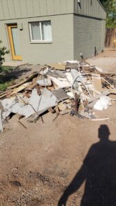 A large outdoor pile of construction and demolition debris, including wood and drywall, ready for J & R Junk Removal in Phoenix, AZ.