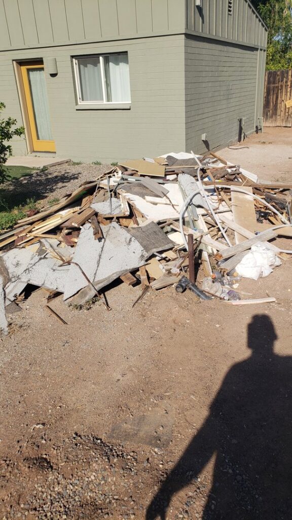 A large outdoor pile of construction and demolition debris, including wood and drywall, ready for J & R Junk Removal in Phoenix, AZ.