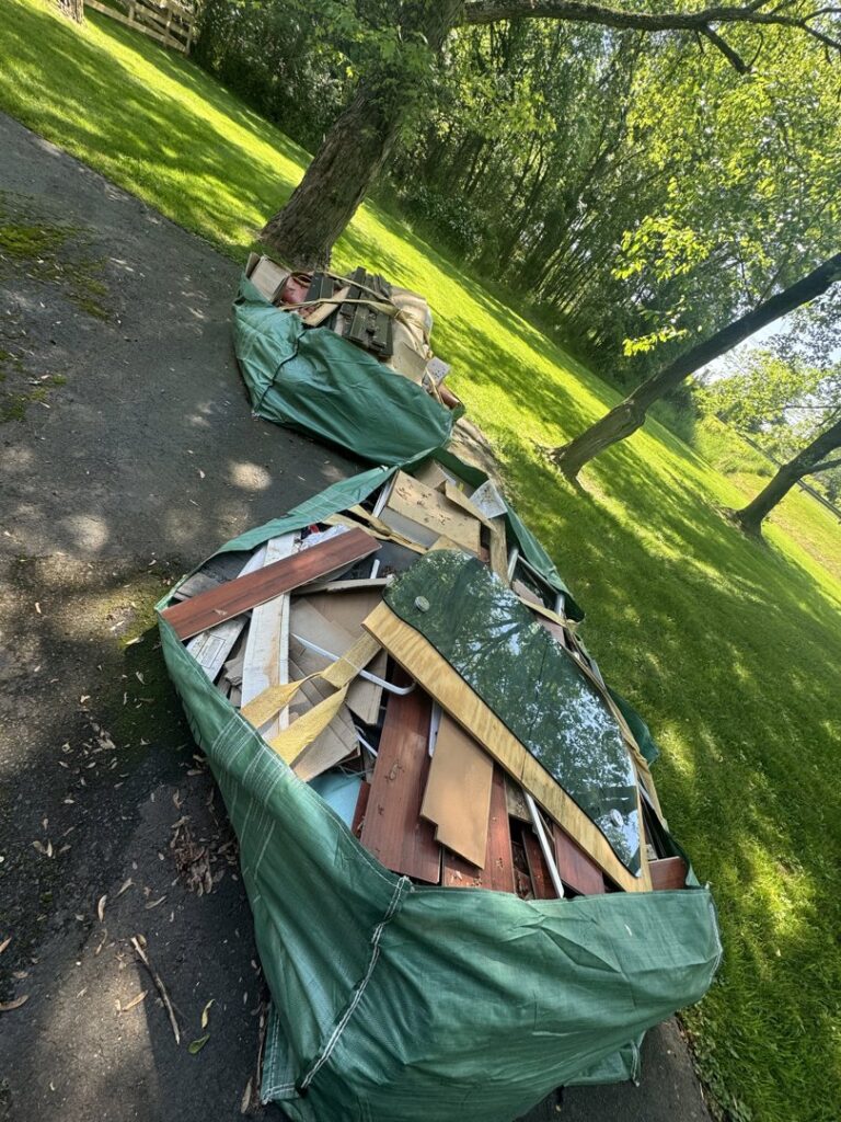 Outdoor furniture, including a chair and umbrella base, along with trash, ready for junk removal by High Speed Junk Removal in Levittown, PA.