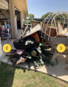A large pile of outdoor yard debris, including wood, a tire, and metal, ready for junk removal by IHaul Austin in Austin, TX.