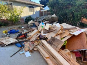 A cluttered patio with boxes, luggage, and old furniture, awaiting junk removal by Zero Junk in San Jose, CA.