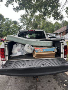 A pickup truck loaded with a mattress, trash bags, and boxes for removal by ONLY Junk Removal Services in Austin, TX