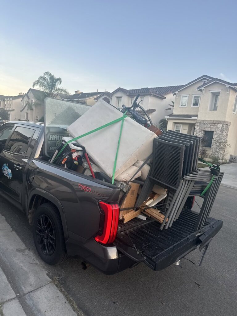 A pickup truck bed fully loaded with various items for general junk removal by Haul Away Any Day in San Diego, CA.
