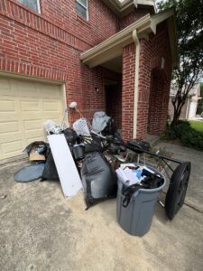 A pile of household trash and unwanted items on a driveway, awaiting general junk removal by Get Junk Help in Houston, TX.