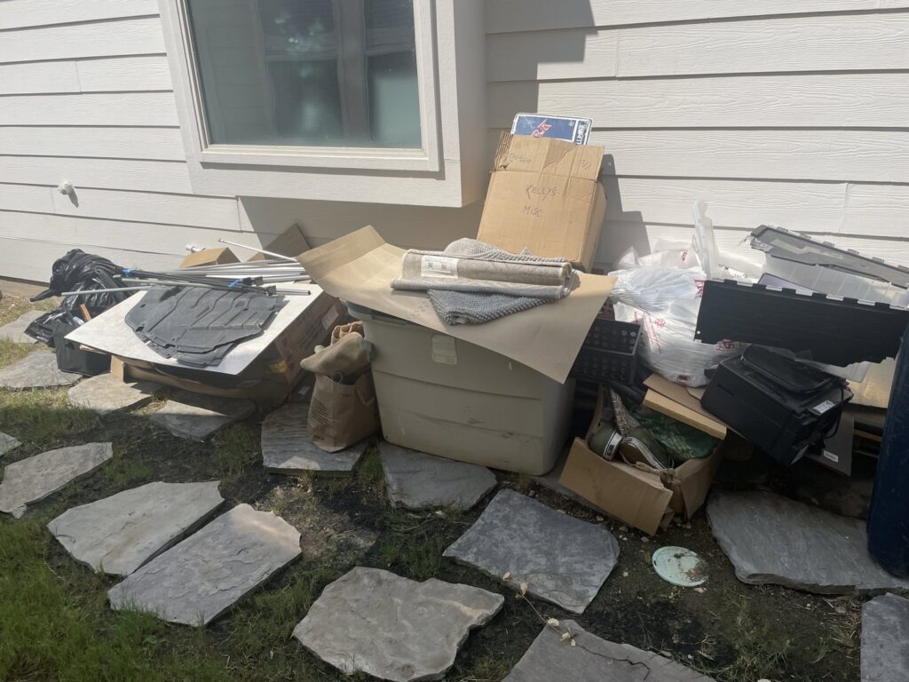 A large pile of household junk, boxes, and debris stacked outside a residential home, ready for removal by All Needz Junk Removal & Hauling Service in Dallas, TX.